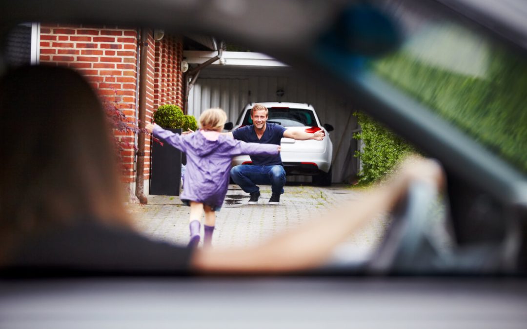 A young girl running out of her moms car excitedly to go hug her dad